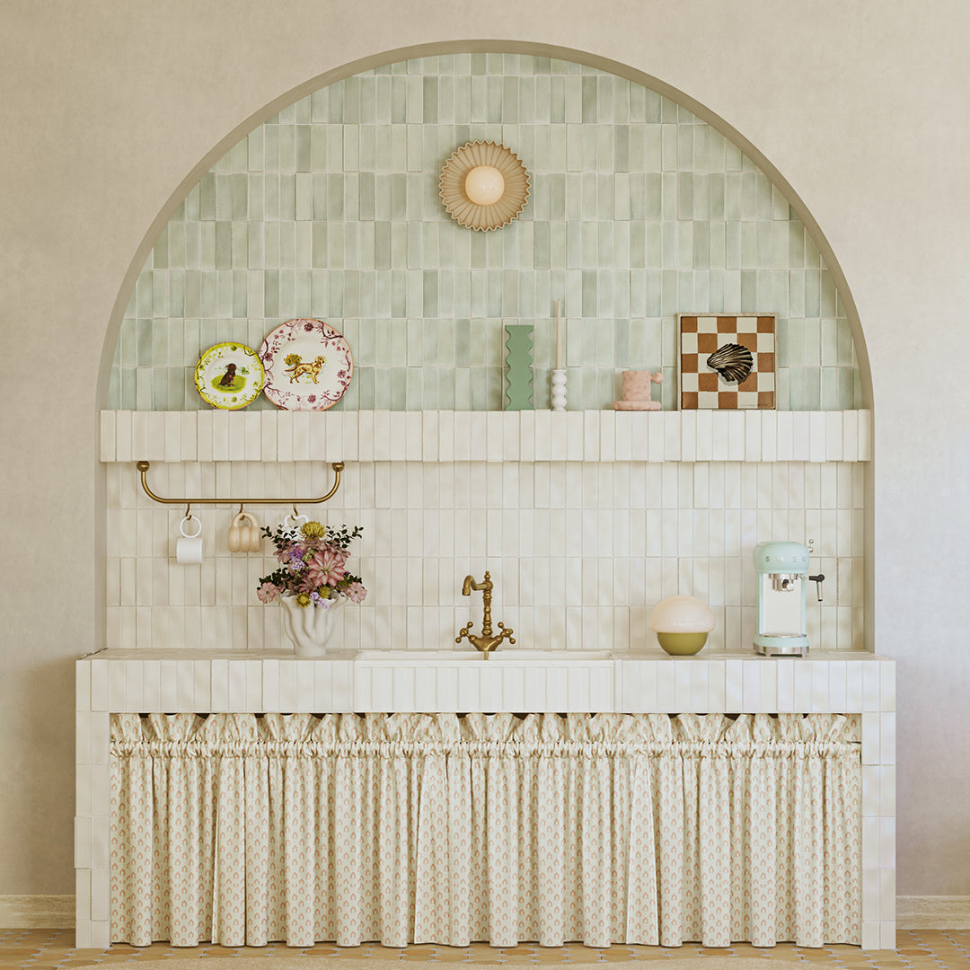 Decorative wall with tiled arch and shelves, featuring decorative items and a small sink.