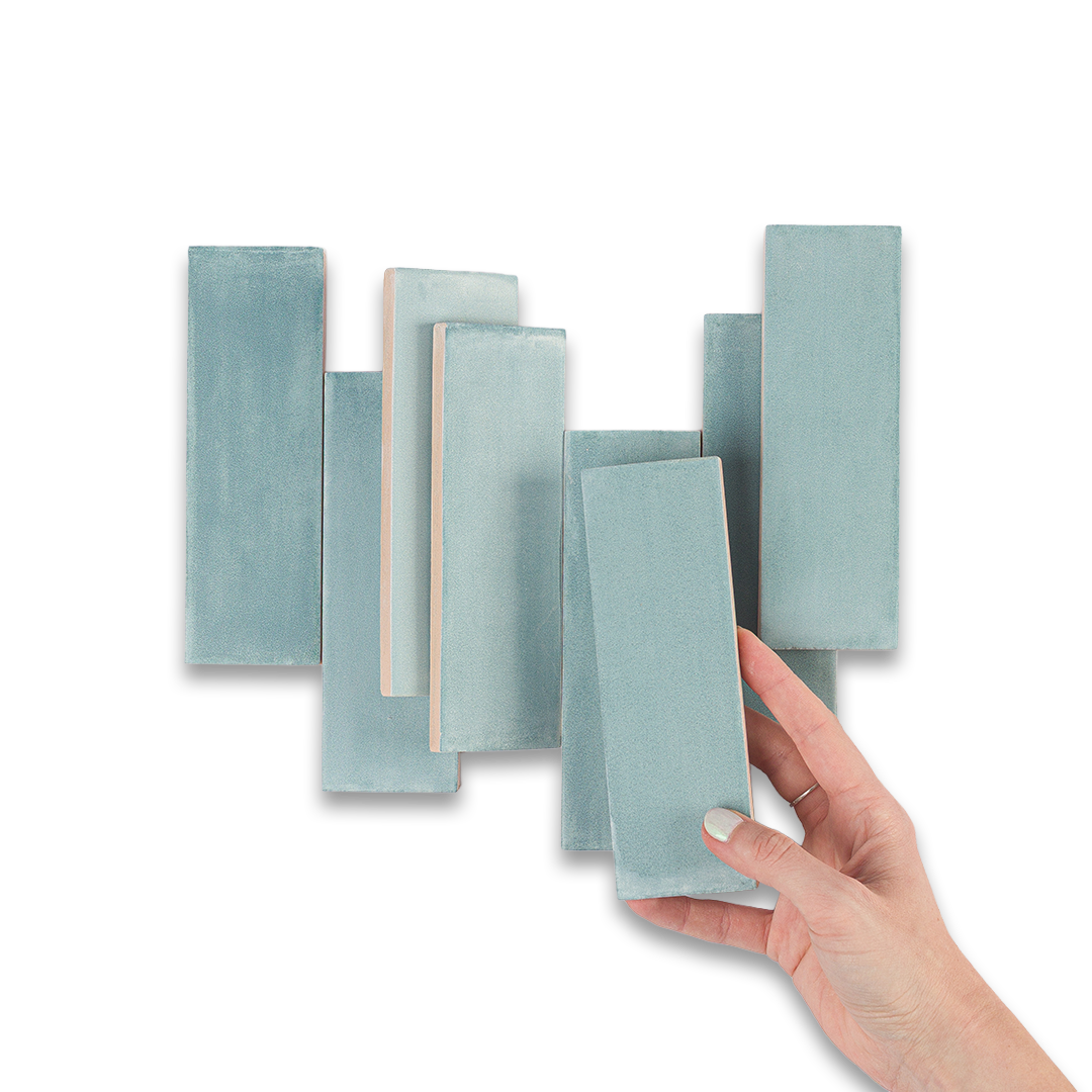 Set of light blue rectangular tiles with a hand holding one tile against a white background