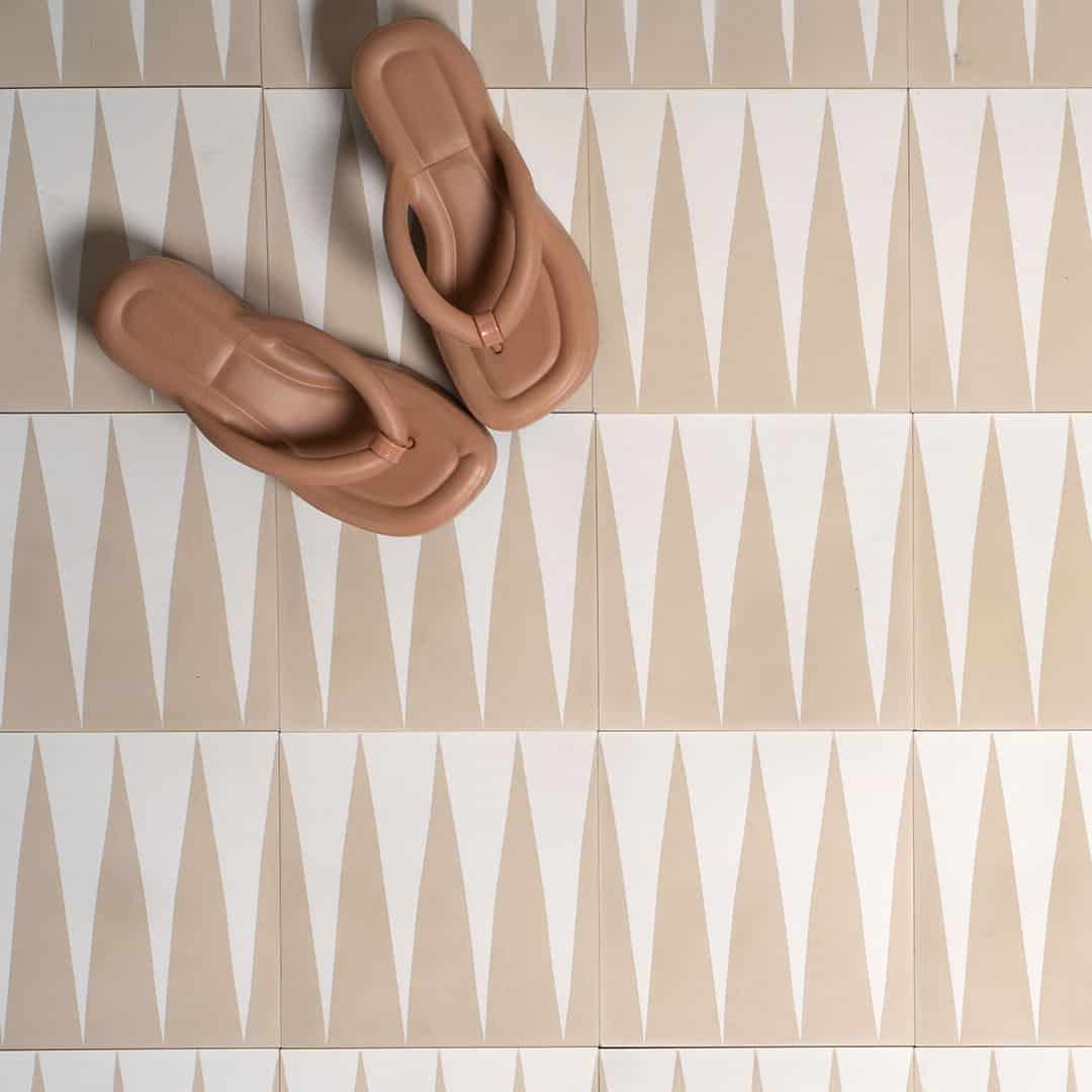 An alternating beige and white elongated triangular patterns forming a geometric zigzag motif, ideal for modern flooring, wall accents, or Scandinavian-inspired interior decor.