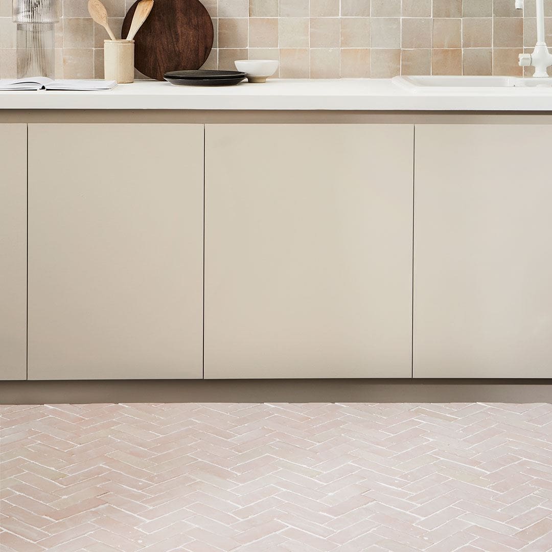 Floor is laid in a light pinkish-beige herringbone pattern, creating a clean and contemporary look.