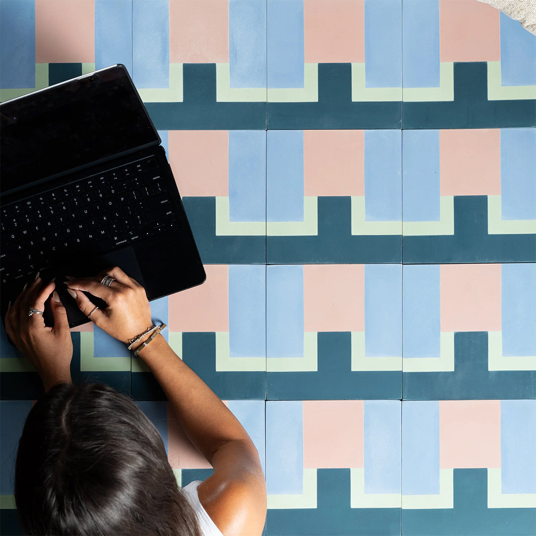 Person using a laptop on a colorful geometric-patterned floor
