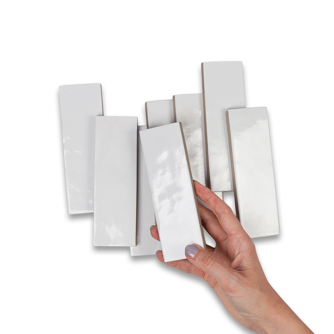 Hand holding a white rectangular tile against a white background
