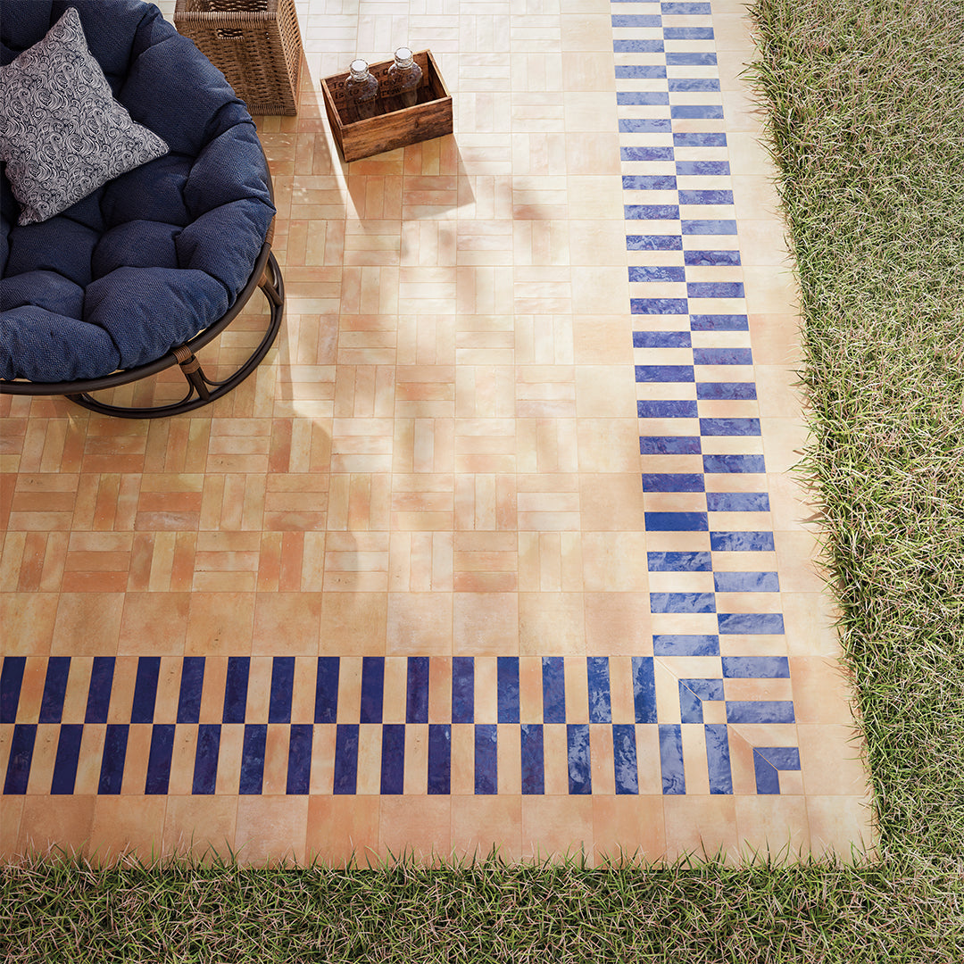 Outdoor rug with blue and brown pattern on grass
