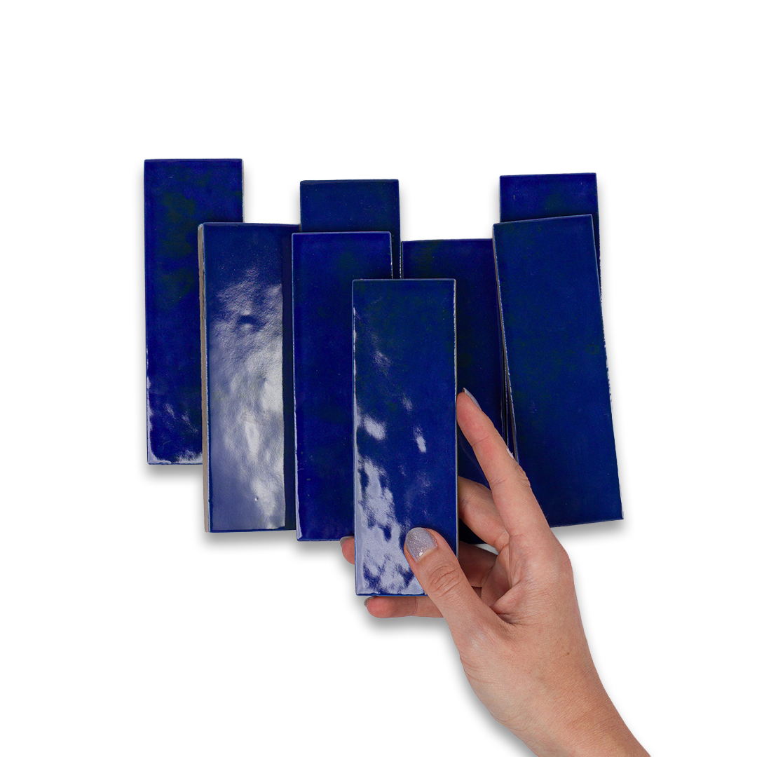 Set of blue rectangular tiles with a hand holding one tile against a white background