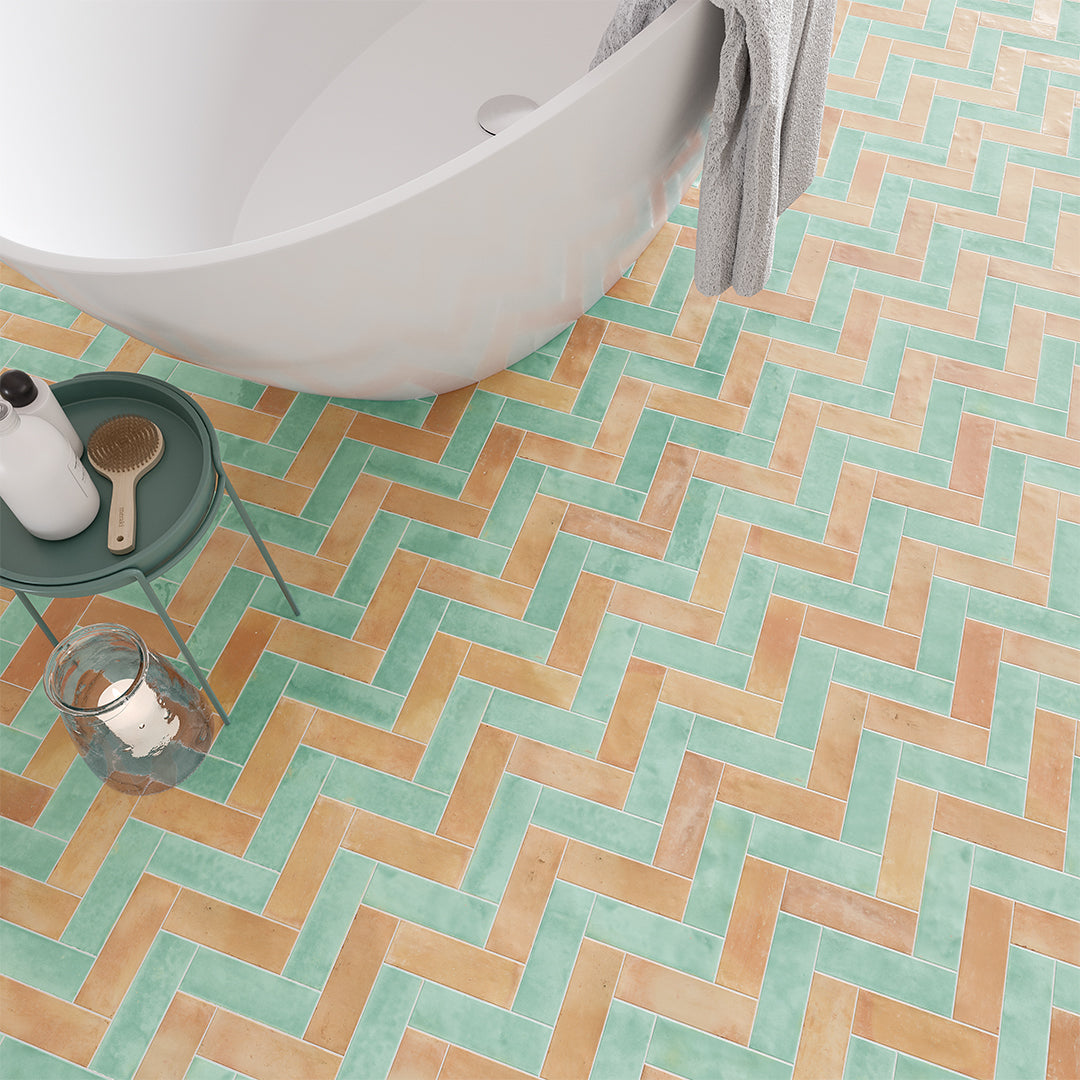 Bathroom with a white bathtub and a patterned tiled floor.