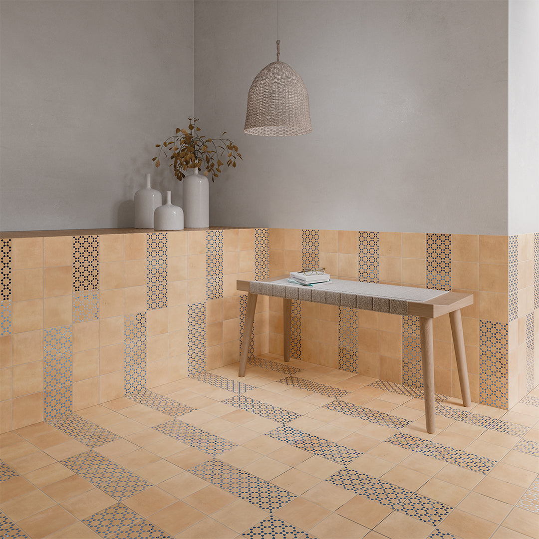 Beige tiles with geometric patterns in a room with a wooden table and decorative items.
