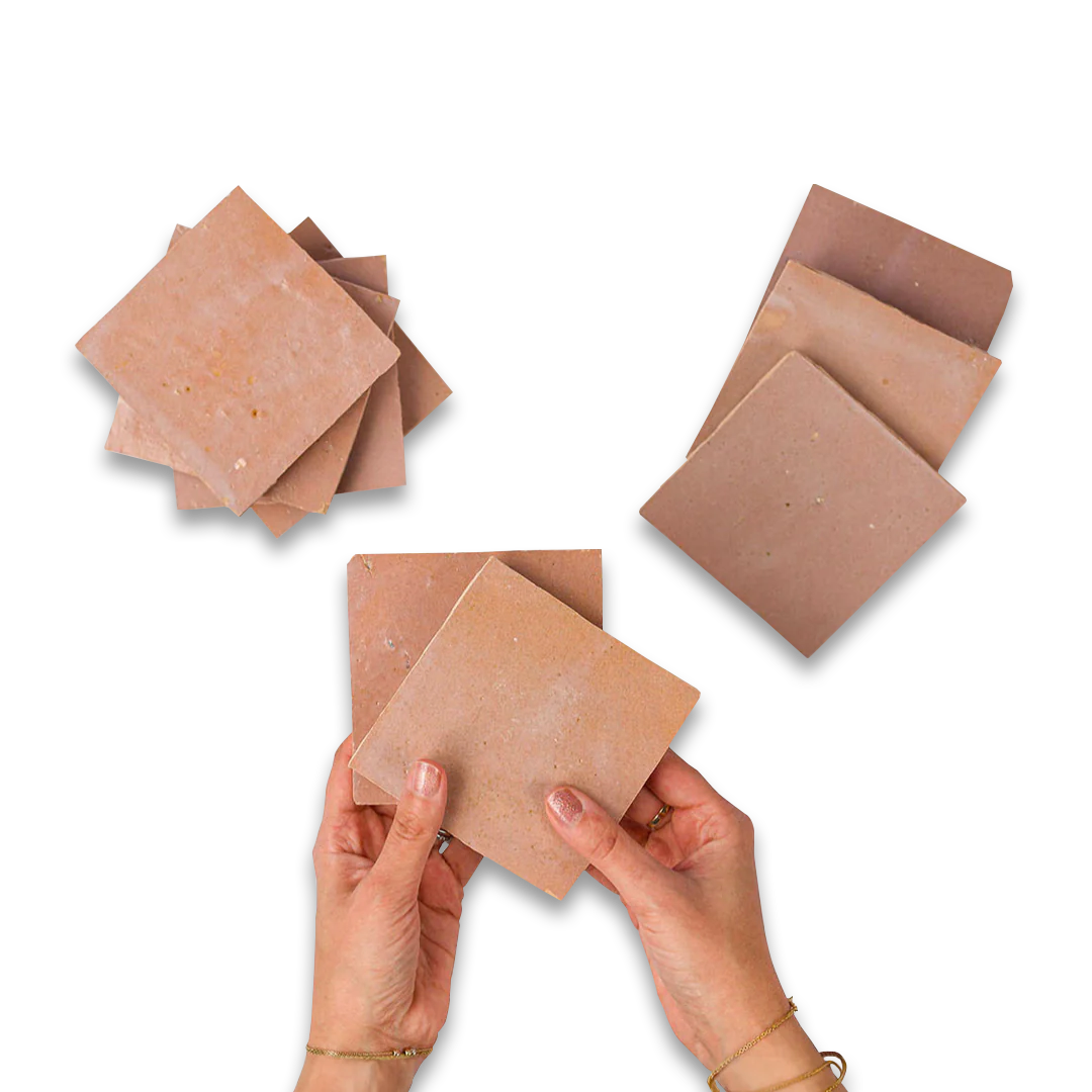 Hands holding a stack of brown square sheets against a white background