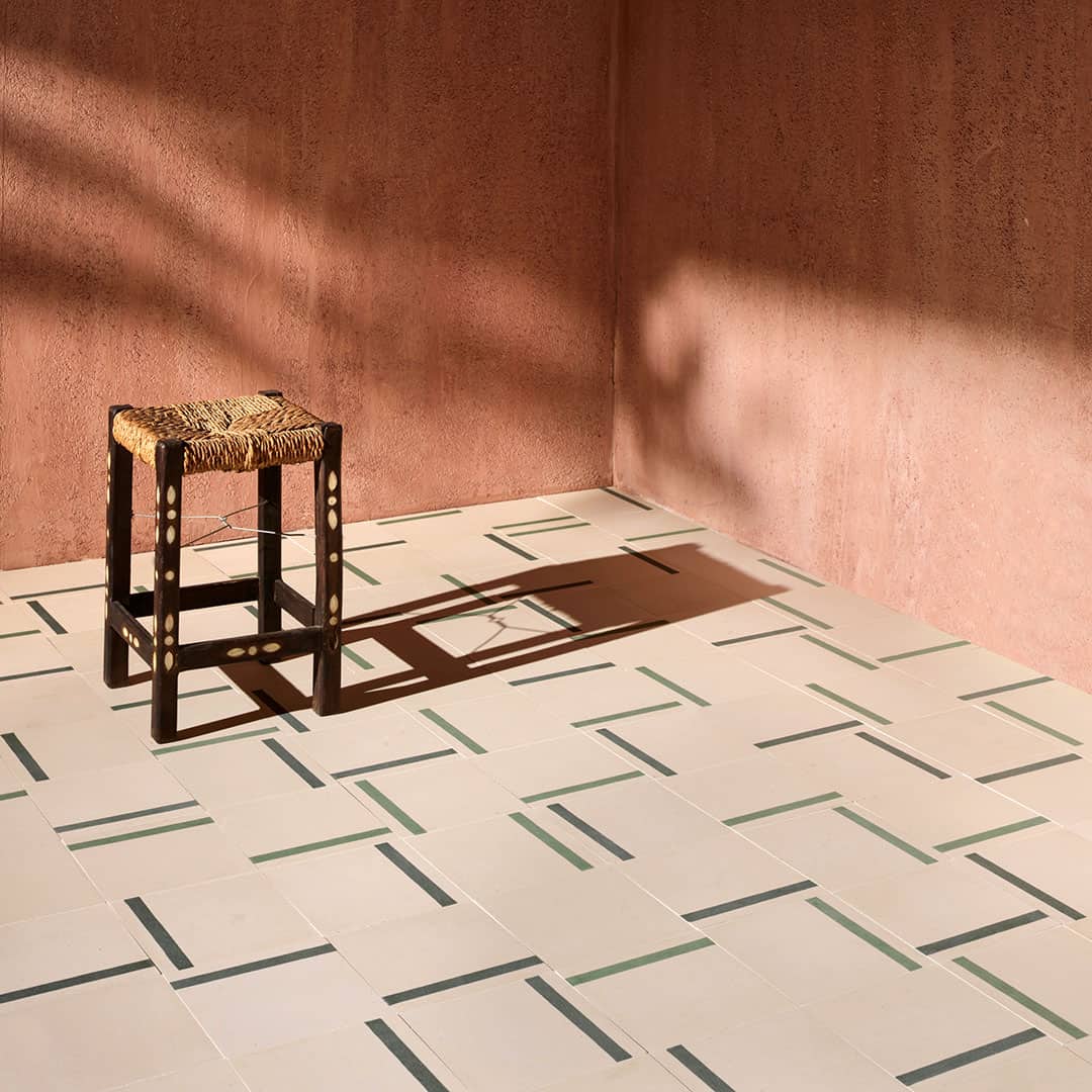 A decorative tile featuring a smooth soft beige background complemented by a bold green accent stripe, perfect for modern interior designs.