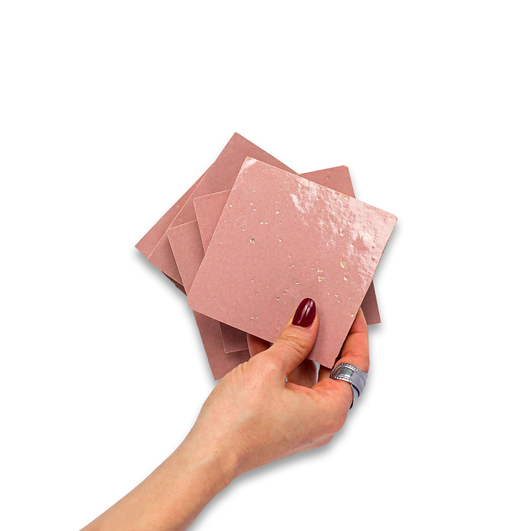 Hand holding pink textured cards against a white background