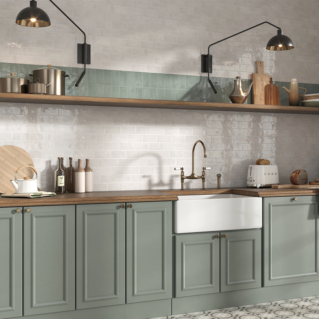 Modern kitchen with green cabinets, wooden countertops, and a white sink.