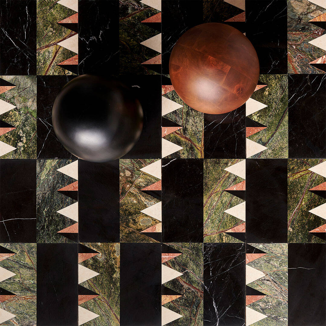 Geometric marble tile pattern with black, green, and cream tones, styled with decorative spheres.