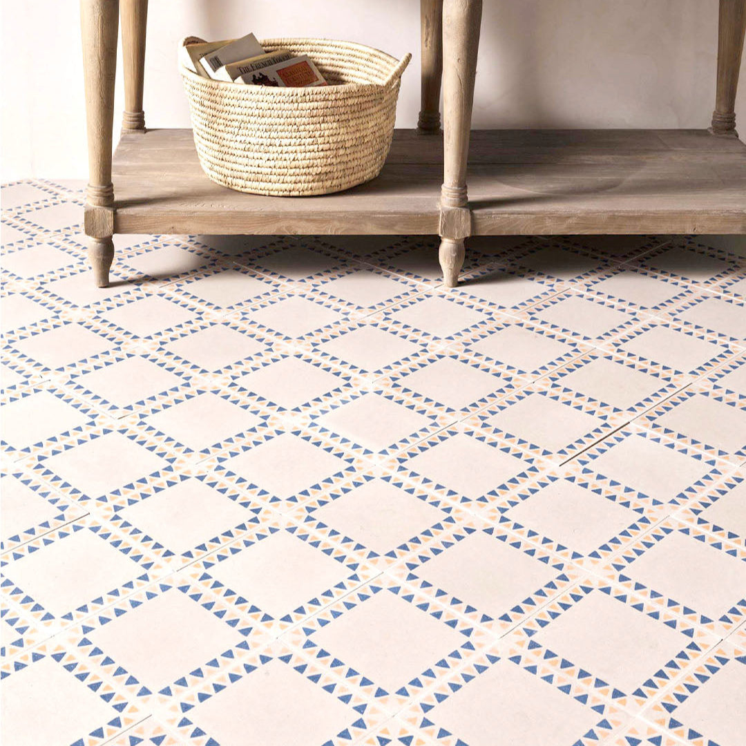 Patterned floor tiles with a wooden shelf and basket in the background