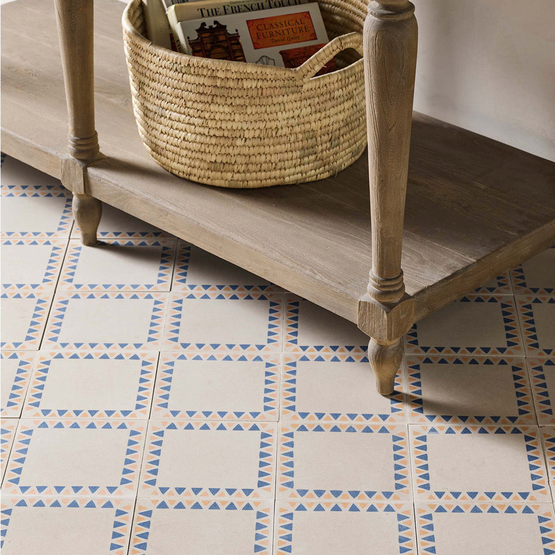 Wooden side table with a woven basket on a patterned tiled floor