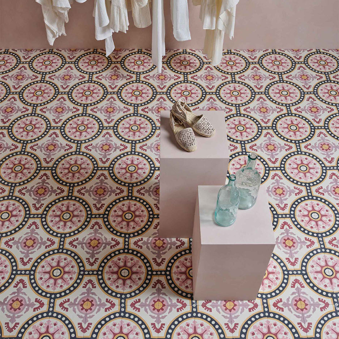 Decorative patterned tiles with a small table and shoes on a pink background