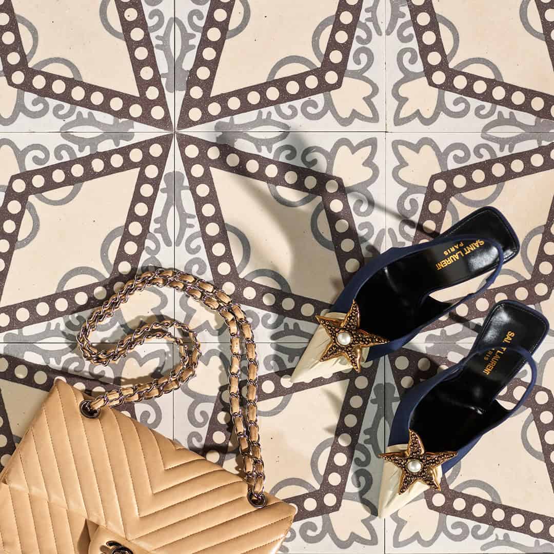 Square cement tile featuring a central diamond pattern with white circular dots and grey floral motifs on a beige background.