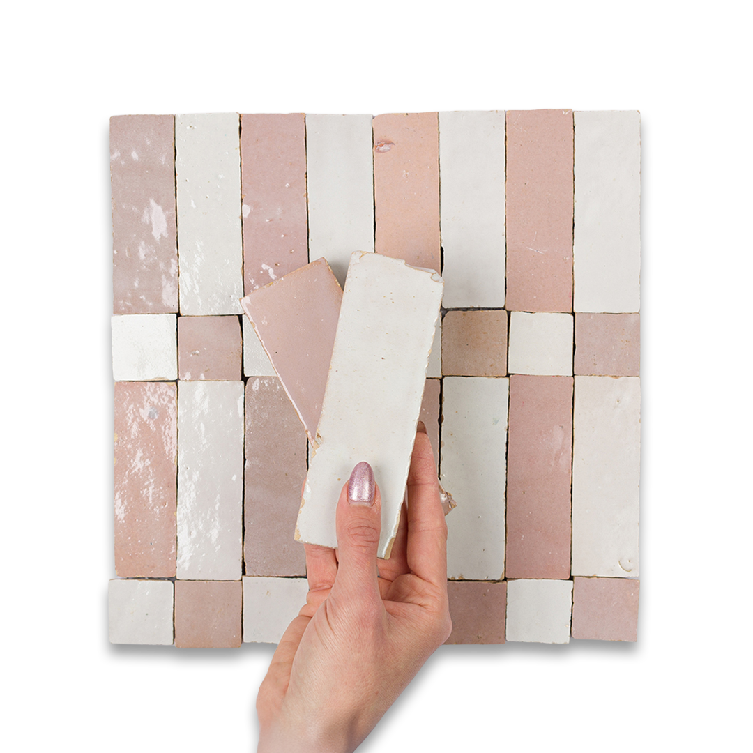 Hand holding a folded napkin over a woven mat with pink and white pattern on a white background
