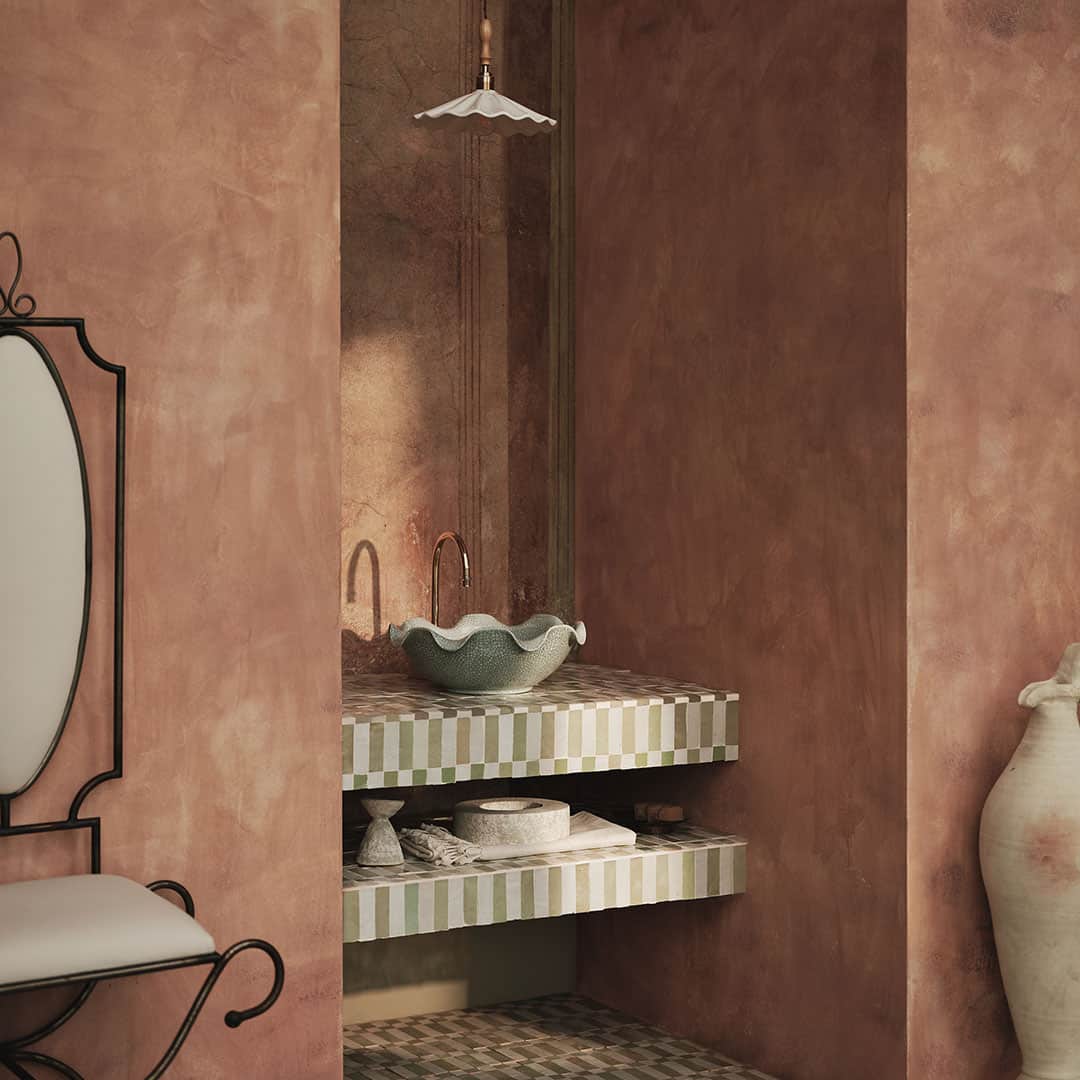 A serene bathroom scene featuring a green ceramic sink with a unique wavy design, placed on striped green and white tiles.