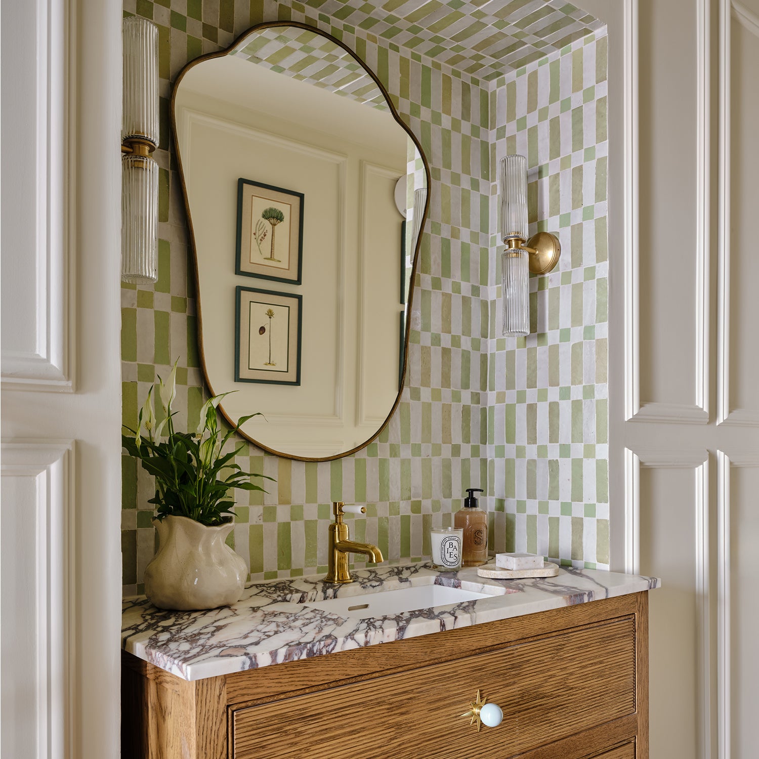 Bathroom vanity with marble countertop, wooden cabinet, and decorative mirror.