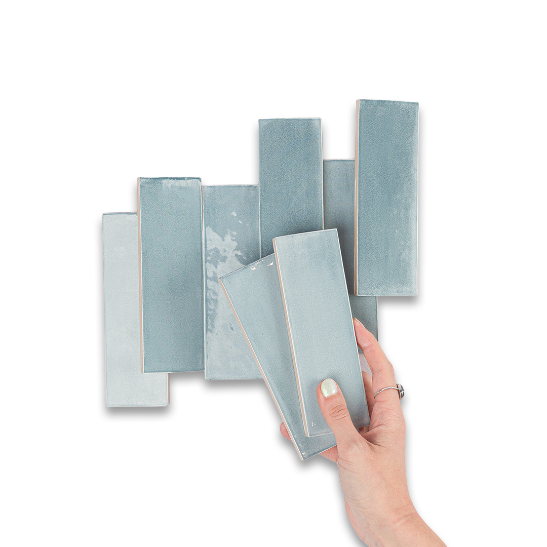 Hand holding a stack of textured blue books against a white background