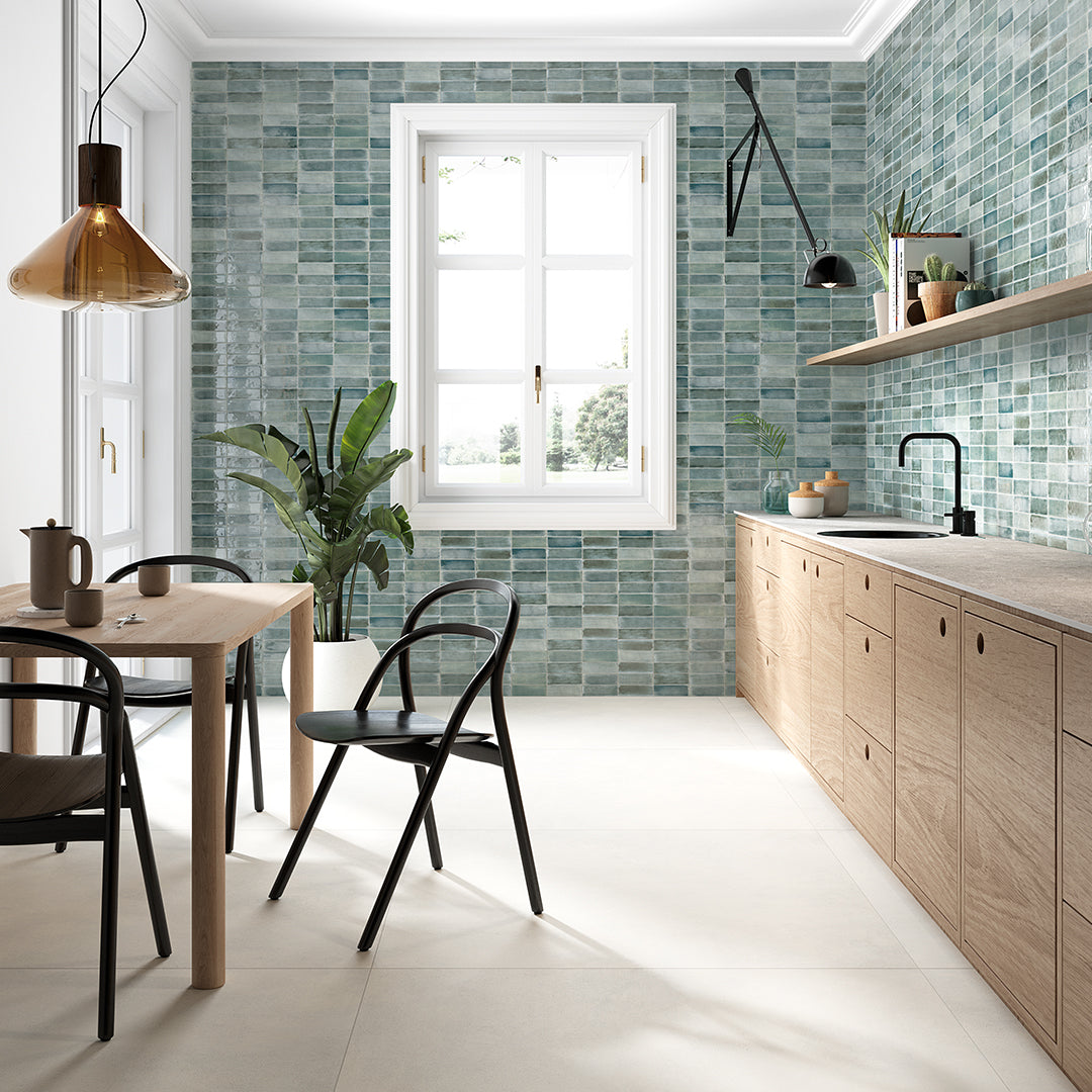 Modern kitchen with wooden cabinets, green tiled walls, and a dining area.