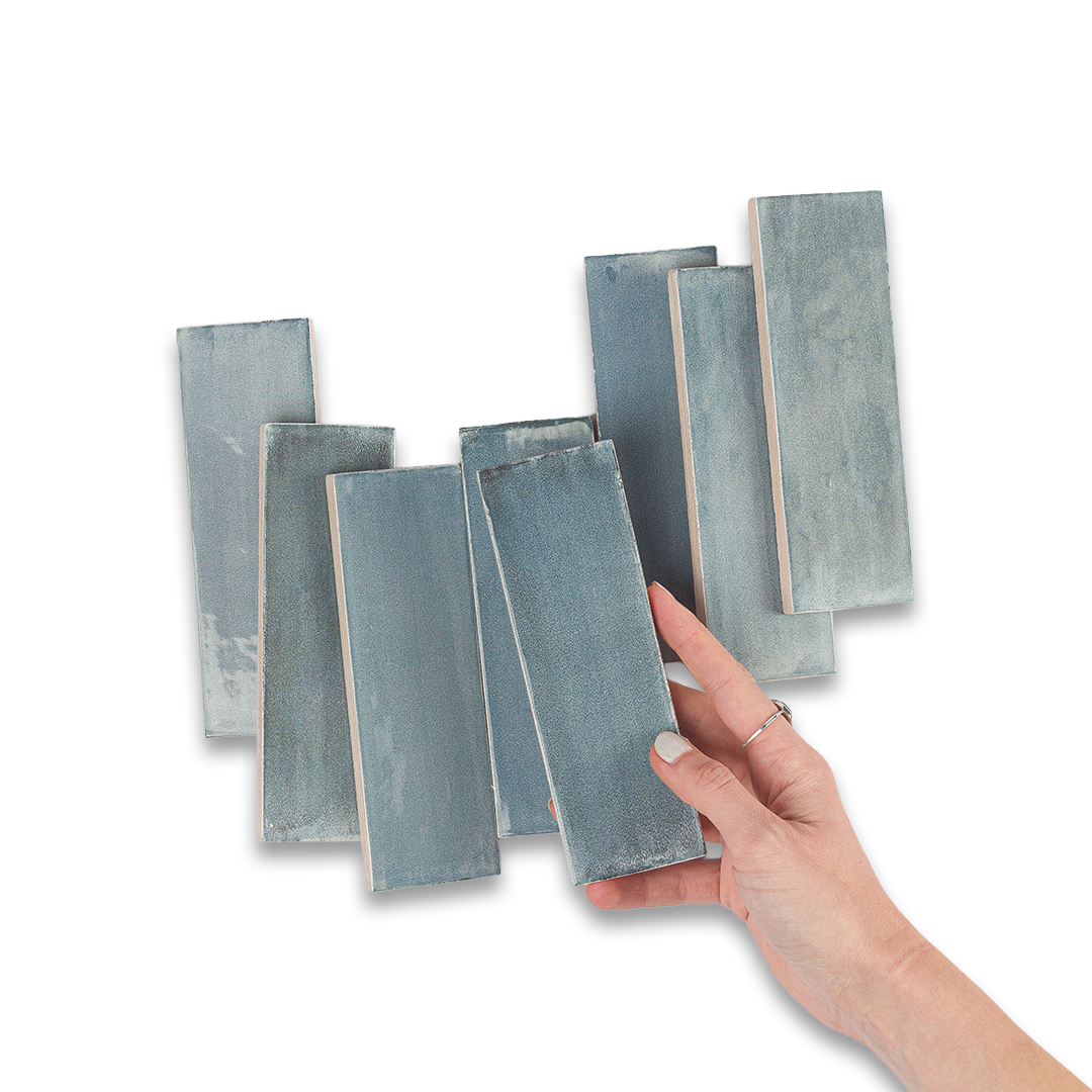 Hand holding a rectangular tile with other similar tiles on a white background
