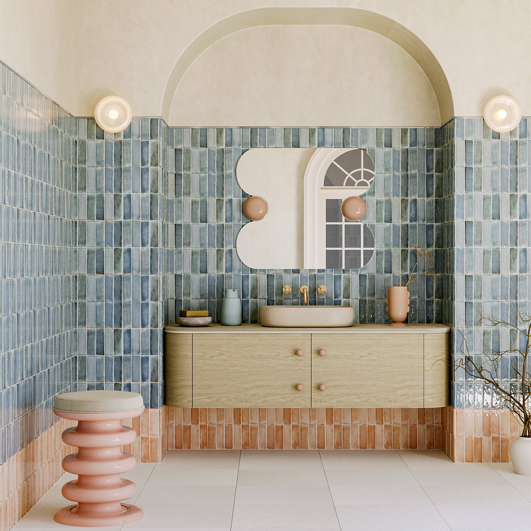 Bathroom with blue tiled walls, a vanity, and decorative elements.