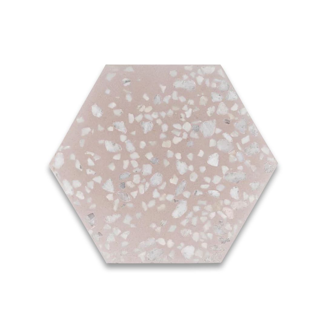 A hexagonal cement tile with a soft blush pink base featuring scattered white and light gray terrazzo-style stone chips, creating a modern, elegant, and textured appearance.
