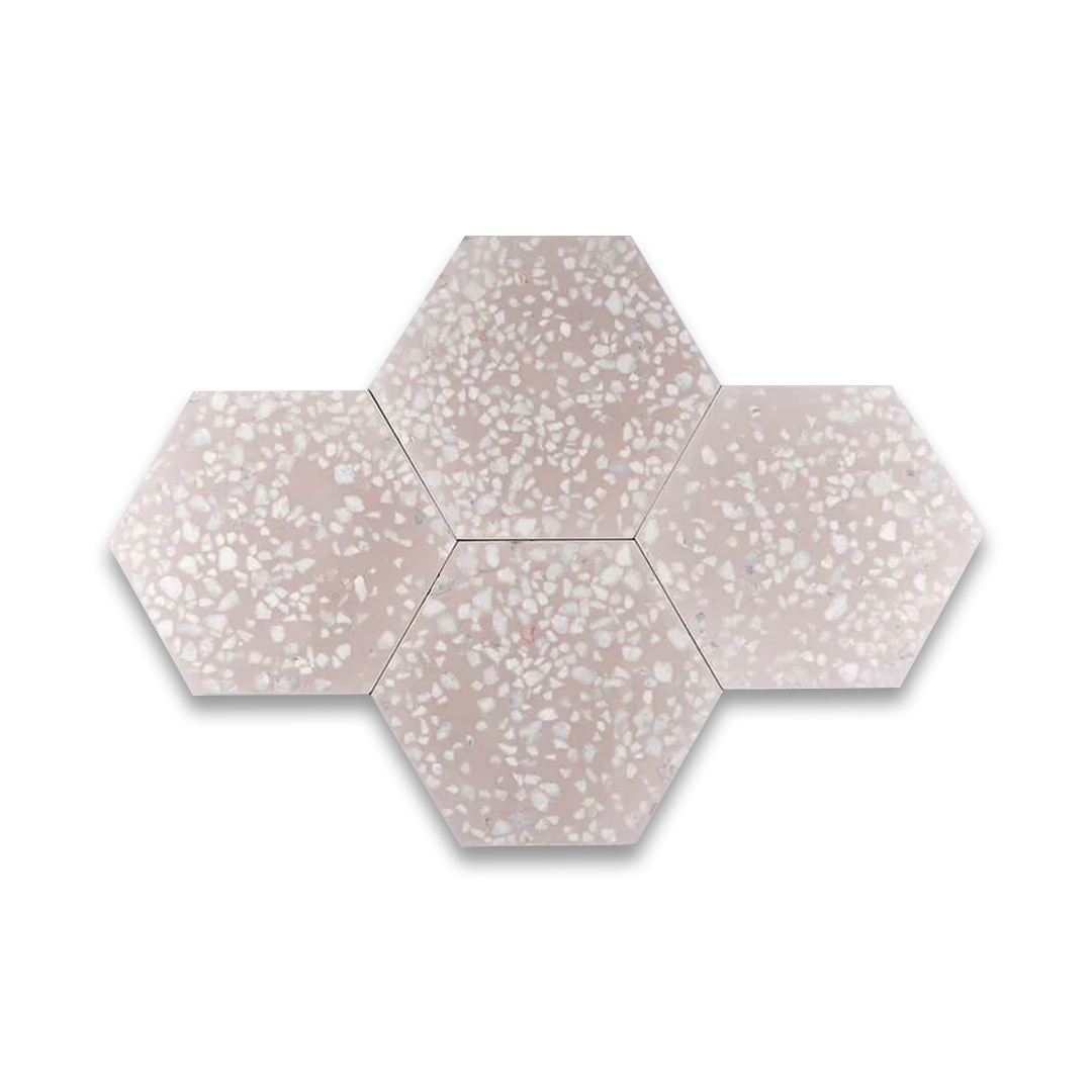 A hexagonal cement tile with a soft blush pink base featuring scattered white and light gray terrazzo-style stone chips, creating a modern, elegant, and textured appearance.