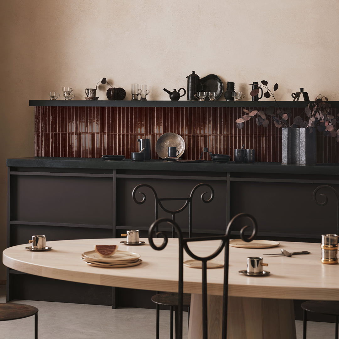 Dining area with a black sideboard, round table, and decorative items.