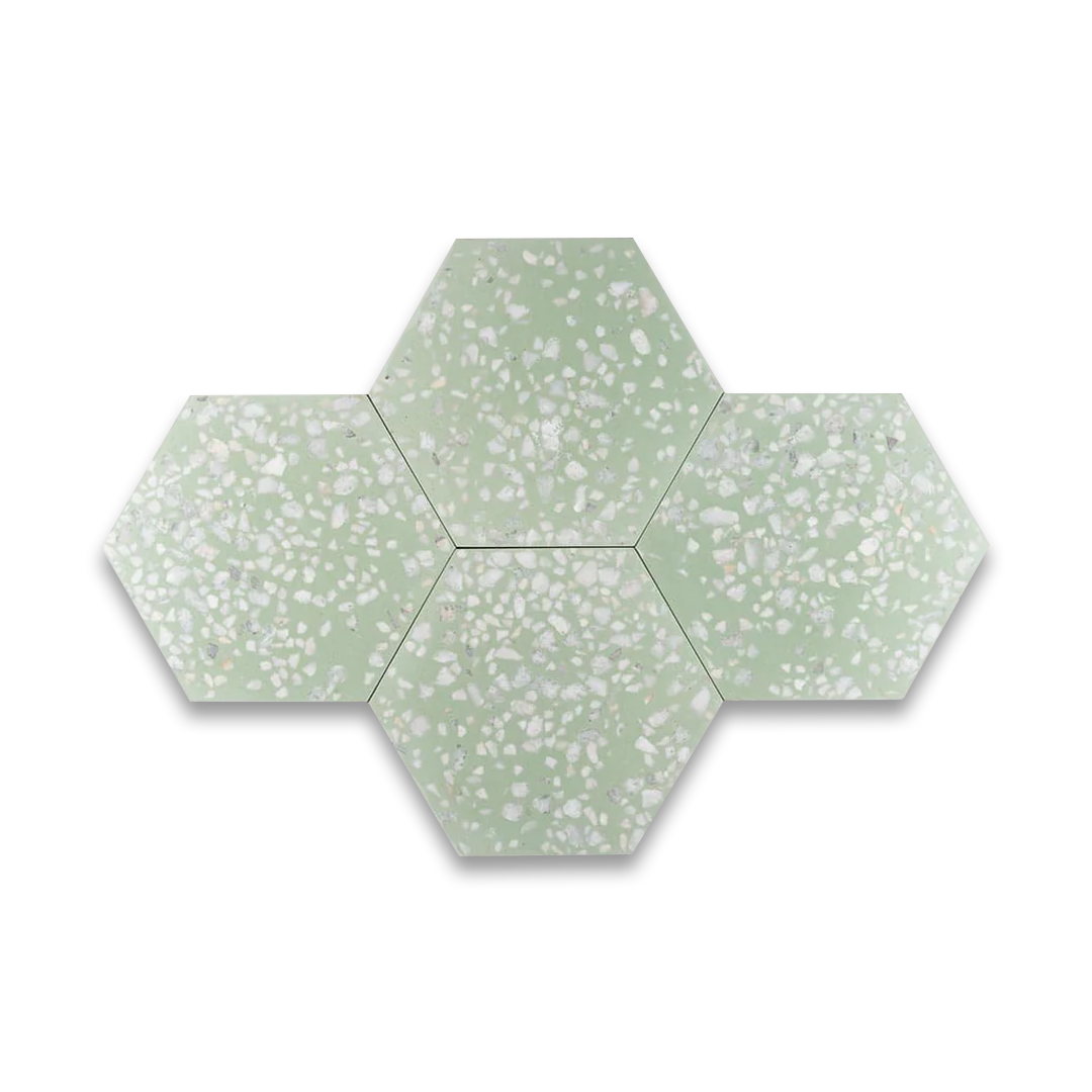A hexagonal cement tile featuring a soft pastel green base with scattered white and light gray terrazzo stone chips, creating a fresh, modern, and textured decorative design.