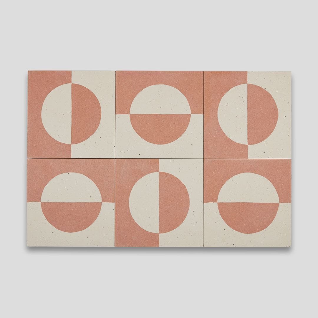 A square cement tile featuring a minimalist geometric design with a terracotta and cream color palette, displaying a half-circle pattern resembling a rising or setting sun.