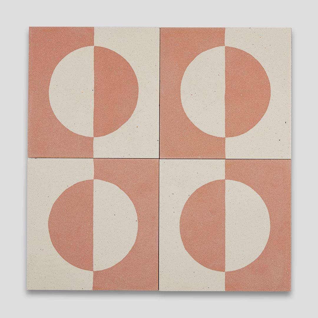 A square cement tile featuring a minimalist geometric design with a terracotta and cream color palette, displaying a half-circle pattern resembling a rising or setting sun.