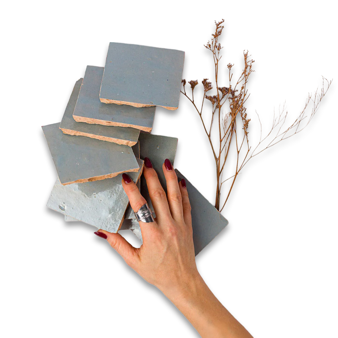 Hand holding a stack of gray ceramic tiles with a minimal background