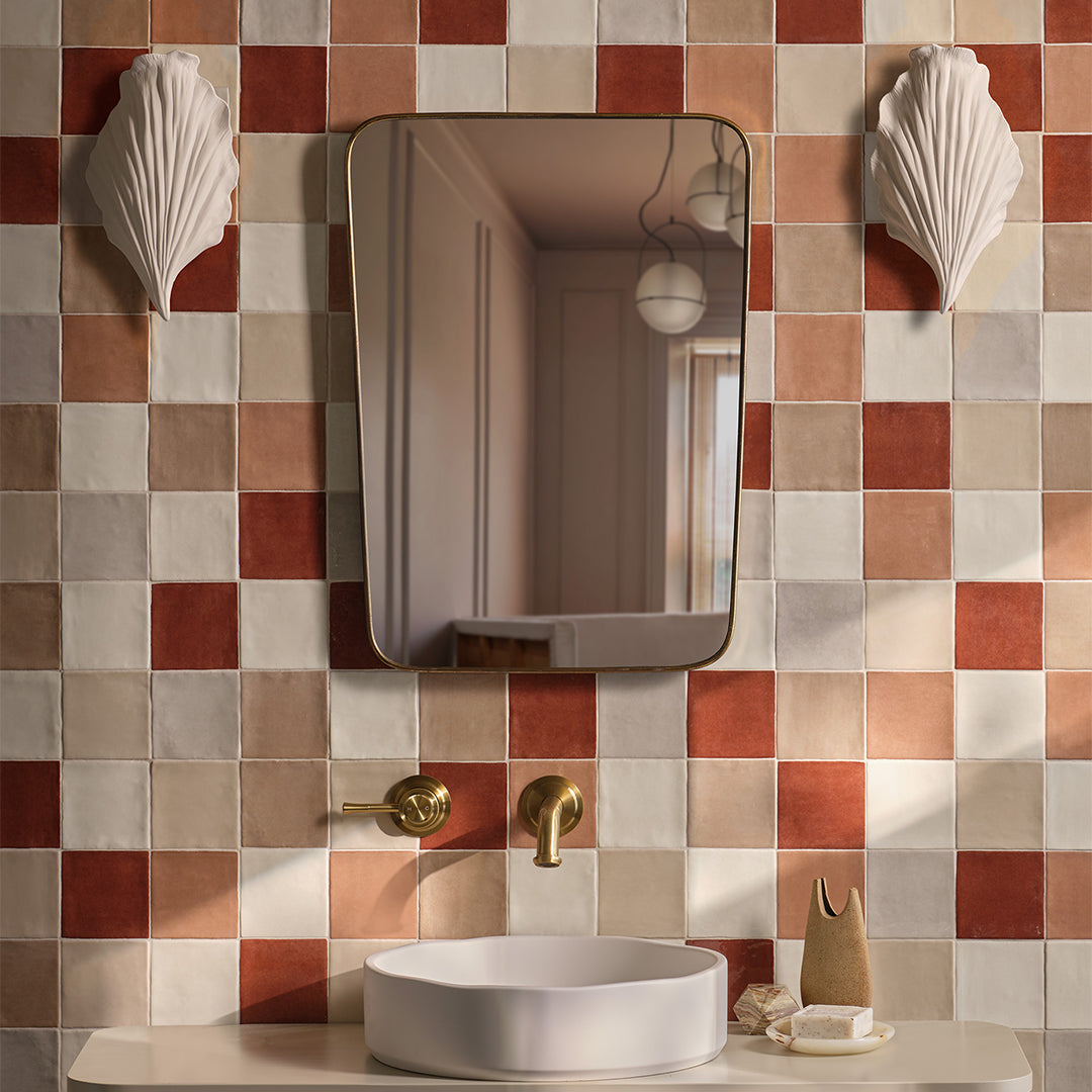 Bathroom with checkered tile wall, mirror, sink, and decorative elements.