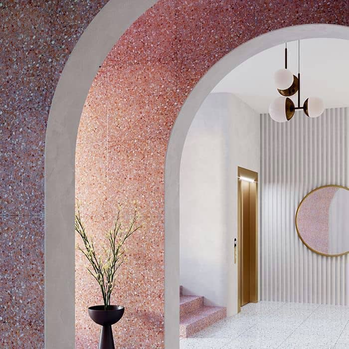 Arched interior with pink terrazzo walls, modern lighting fixture, and minimalist decor in a soft neutral palette.