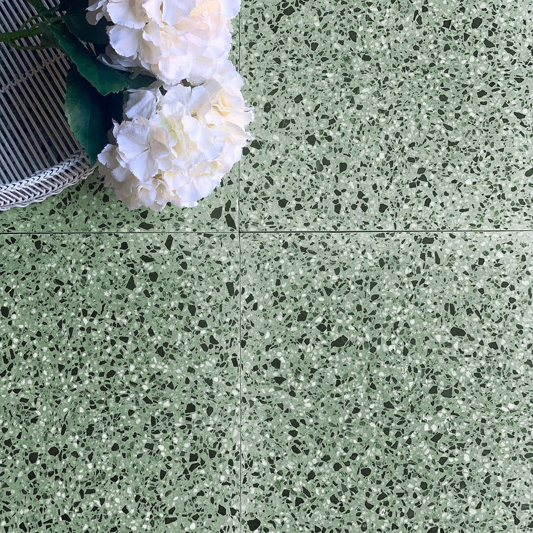 Green terrazzo tile floor with white flowers and woven basket placed in the corner.
