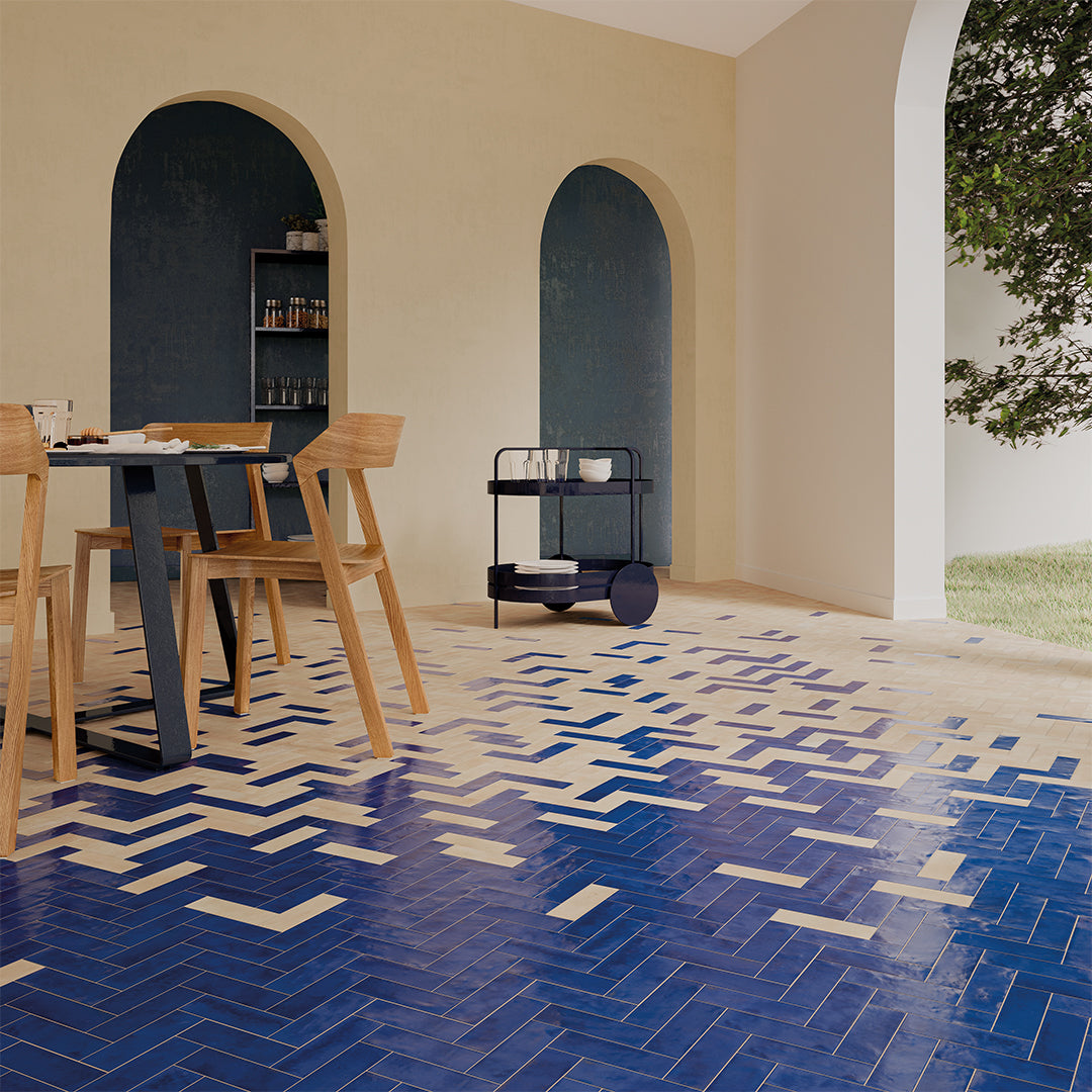 Dining area with blue geometric tile flooring, wooden chairs, and a black cart.