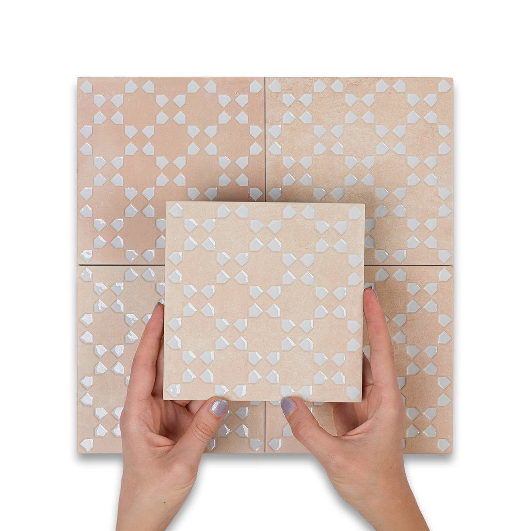Hands holding a square box with heart pattern against a matching tiled background