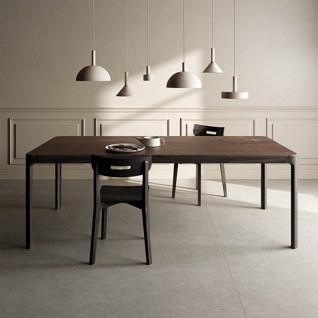 Dining table with chairs in a minimalistic room with pendant lights.