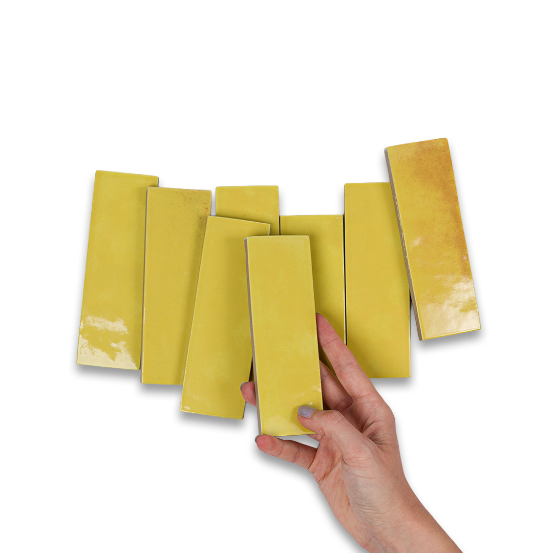 Hand holding a yellow color swatch against a white background