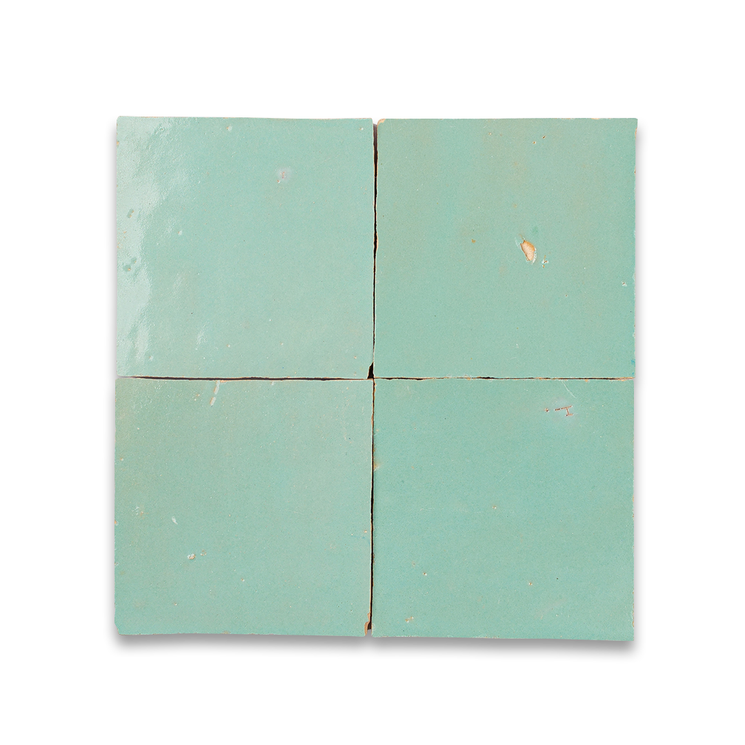 Four square tiles with a light green color on a white background