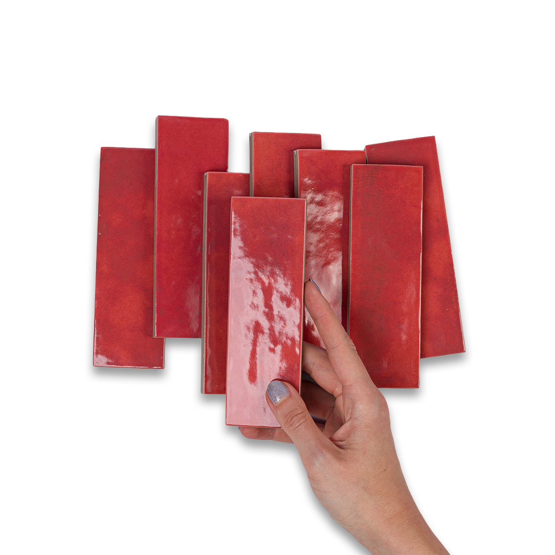 Hand holding a red rectangular object against a white background