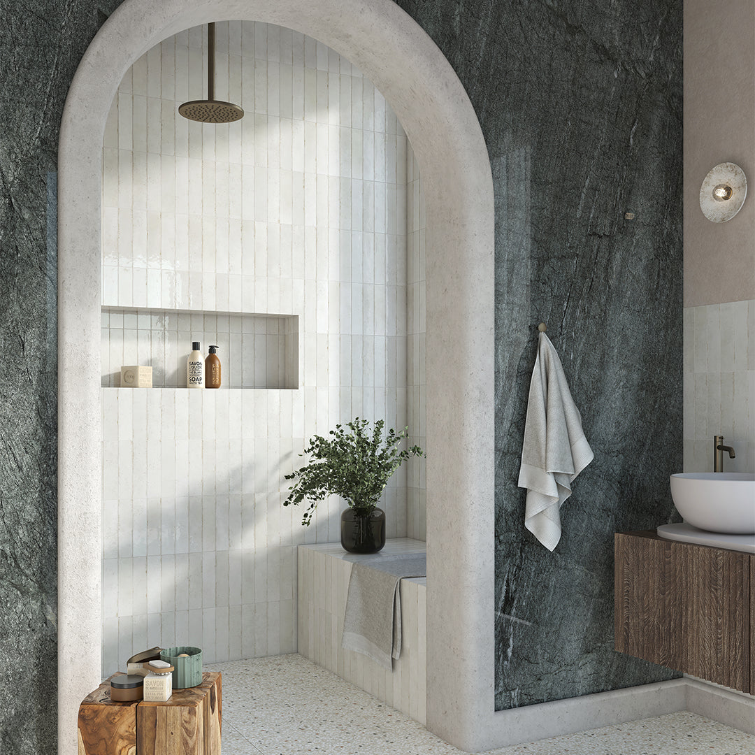 Modern bathroom with archway, marble walls, and wooden fixtures.