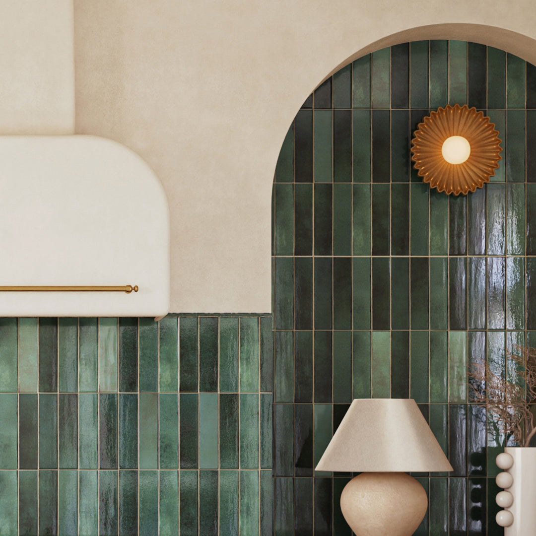 Green tiled wall with a decorative light fixture and lamp.
