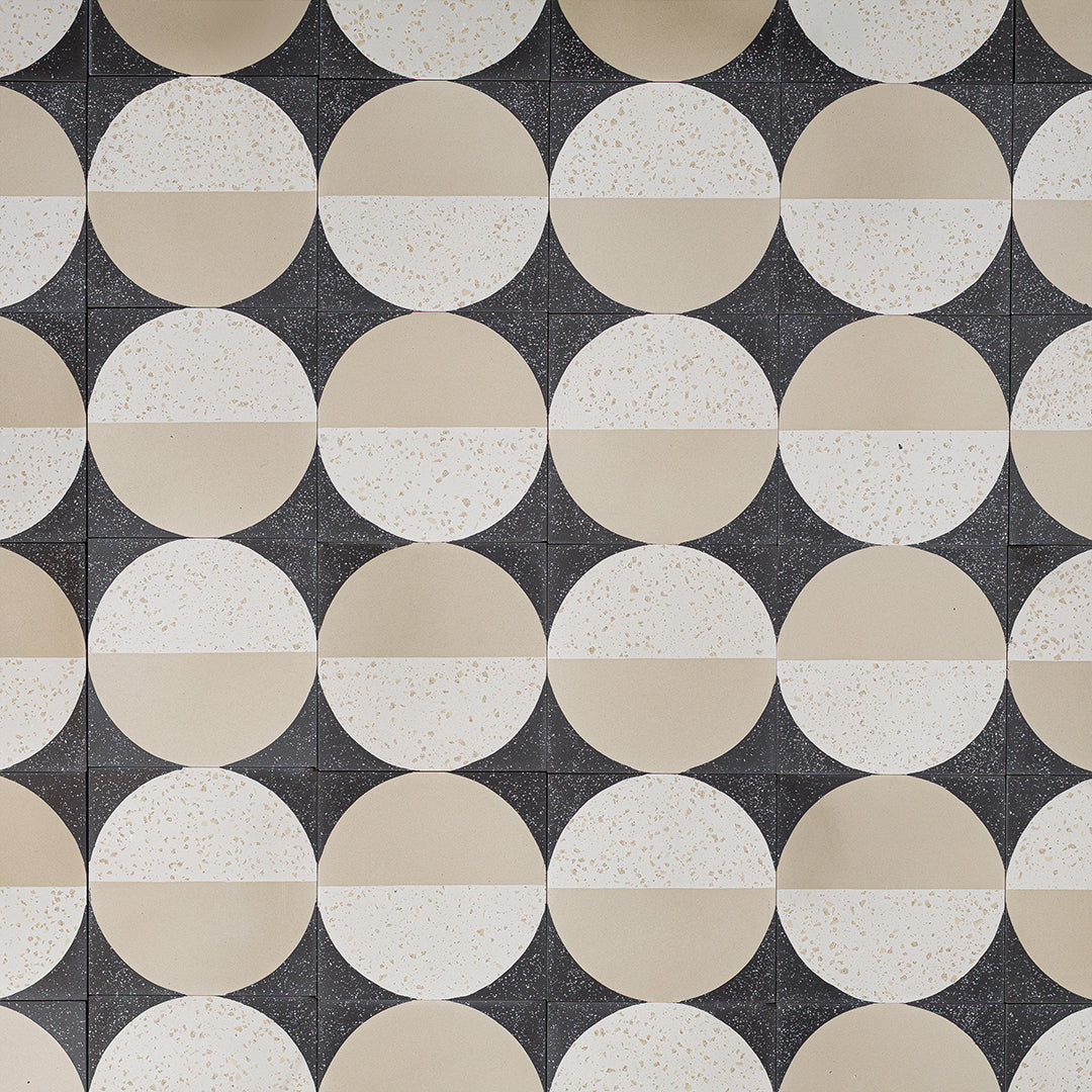 Square cement tile featuring a modern geometric design with a half-beige and half-white terrazzo circle on a dark speckled background, ideal for contemporary flooring and wall décor.