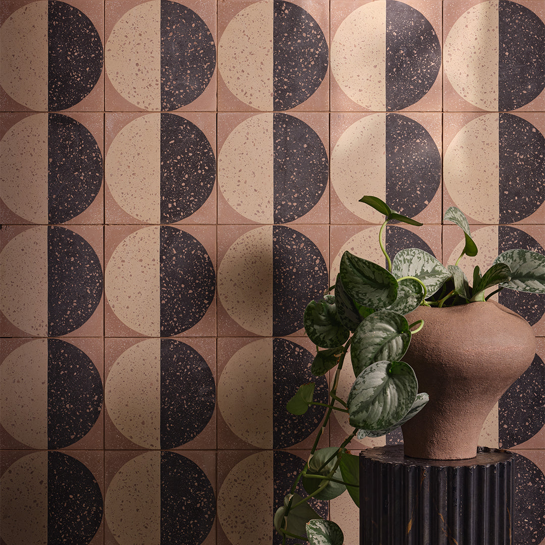 Square cement tile featuring a geometric terrazzo design with a half-black and half-beige circular pattern, showcasing speckled stone textures for modern flooring and wall décor applications.