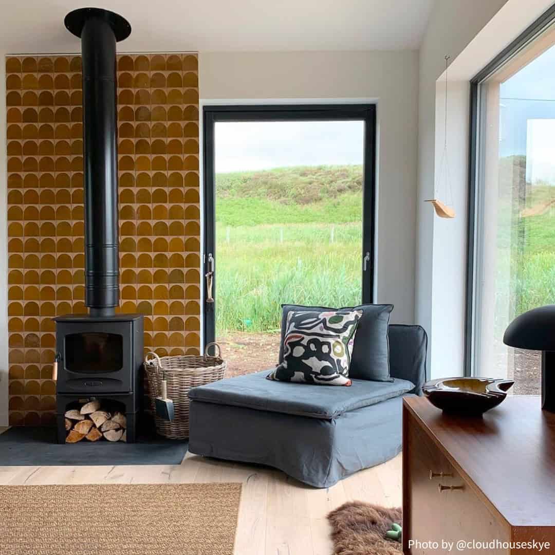 A cozy modern living space with large windows overlooking a grassy landscape.