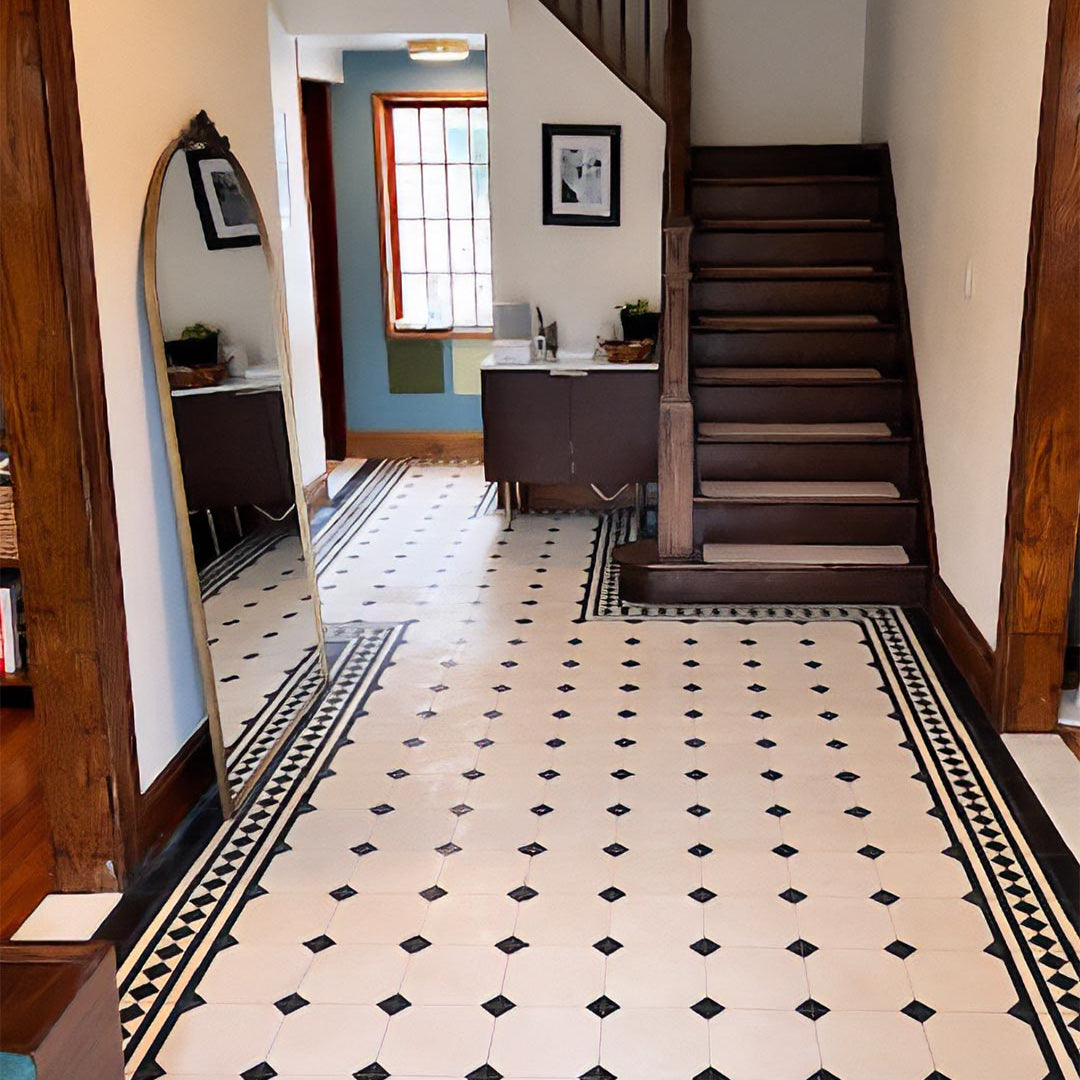 A square cement tile featuring alternating black and beige horizontal stripes with a central row of black diamond shapes, creating a bold, geometric, and modern visual pattern.