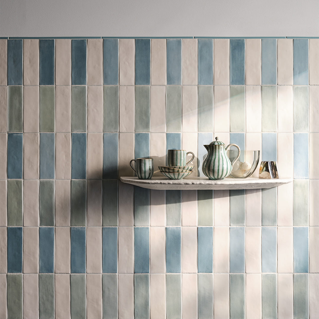 Colorful tiled wall with a shelf displaying ceramic items