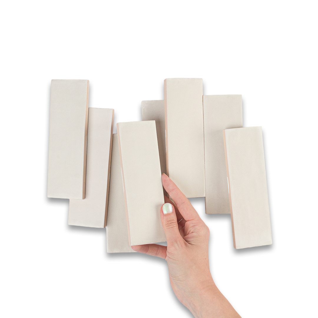 Hand holding a set of beige color swatches against a white background